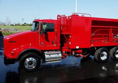 A red slurry seal truck used for asphalt maintenance