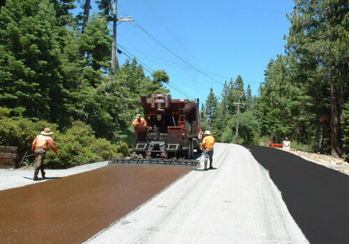 Industrial equipment preparing a roadway for slurry seal