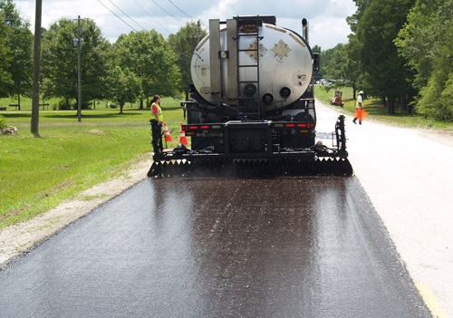 Sealcoat Trucks in Arizona covering a roadway with sealcoat