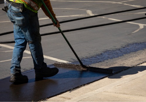 An asphalt repairman tackles a repair job. In addition to Crack Sealers in Iowa, E.D. Etnyre & Co. provides asphalt repair equipment for companies.