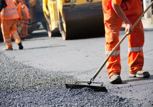 Workers smoothing pavement as part of asphalt repair and maintenance in Nevada